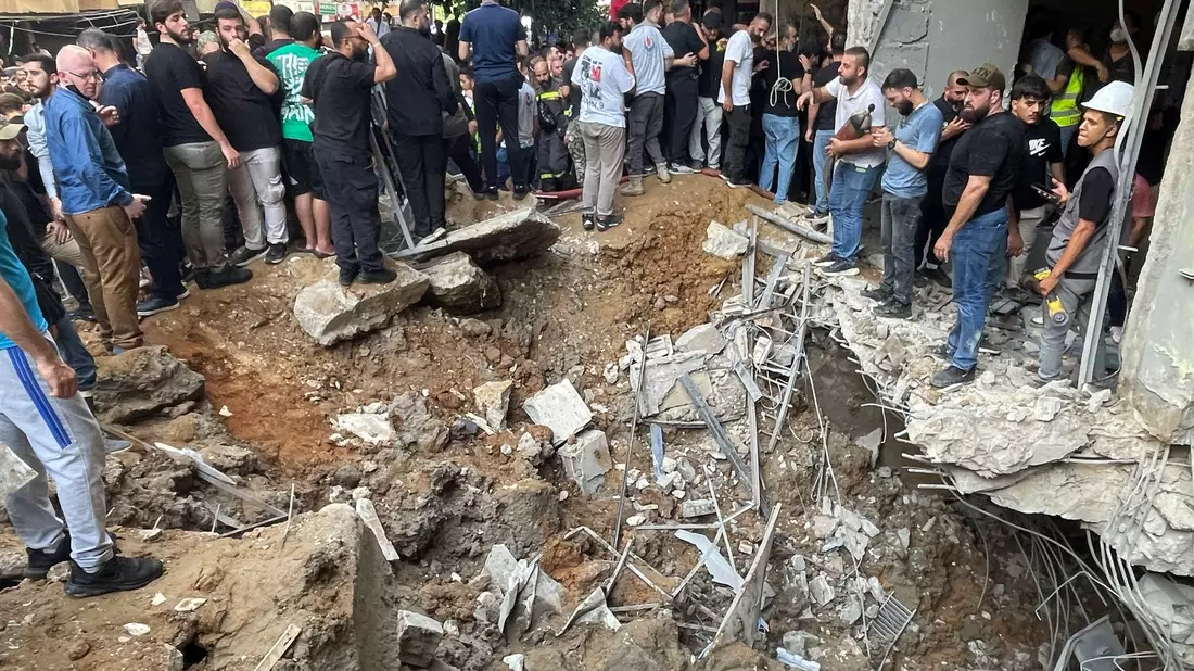 Menschen versammeln sich nach einem israelischen Angriff in Libanons Hauptstadt Beirut. - Bild: Bilal Hussein/AP