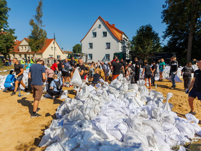 Menschen arbeiten in Polen an der Verstärkung der Deiche. - Foto: Krzysztof Zatycki/ZUMA Press Wire/dpa