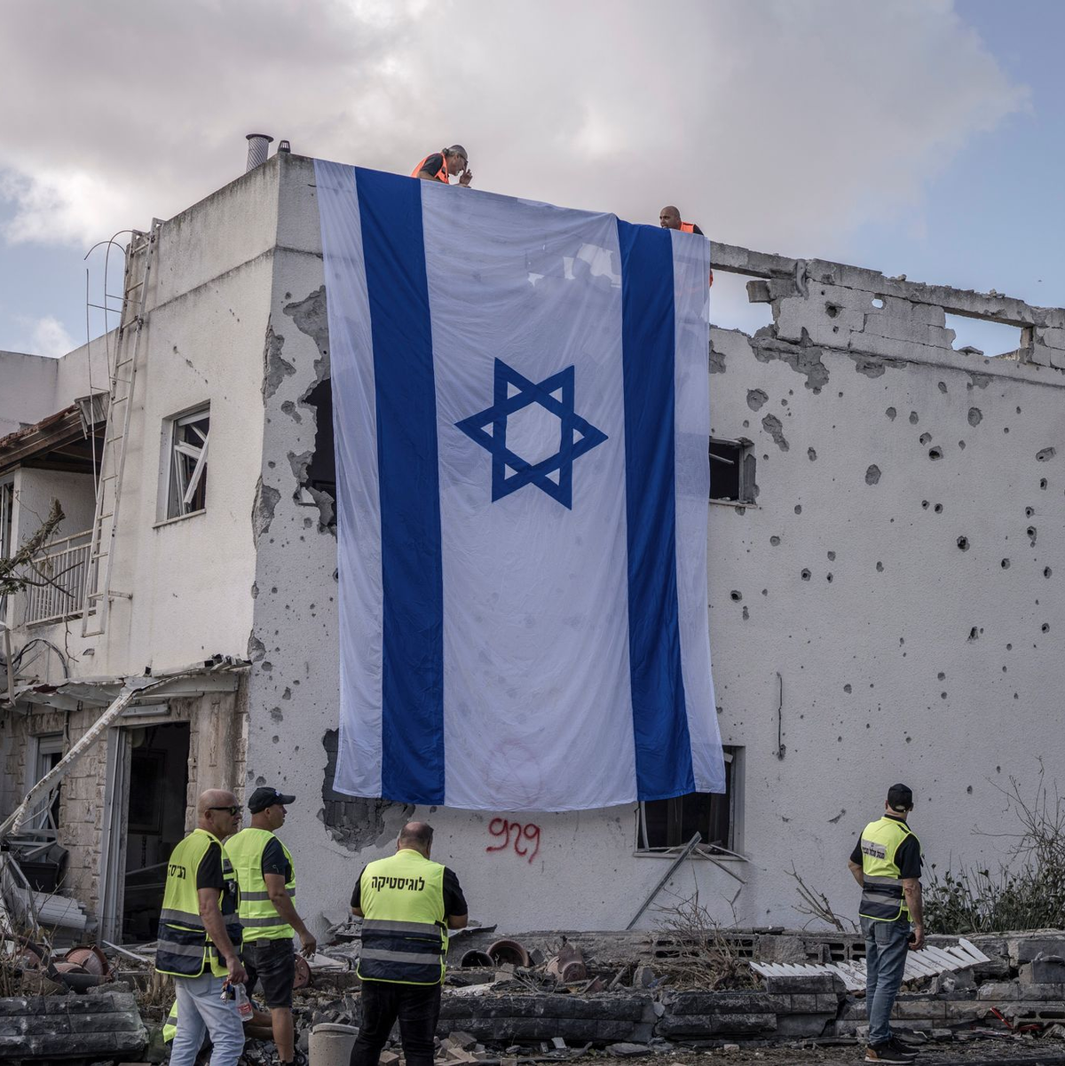 Eine riesige israelische Fahne hängt vom Dach eines beschädigten Gebäudes in Kiriat Bialik. - Foto: Ilia Yefimovich/dpa