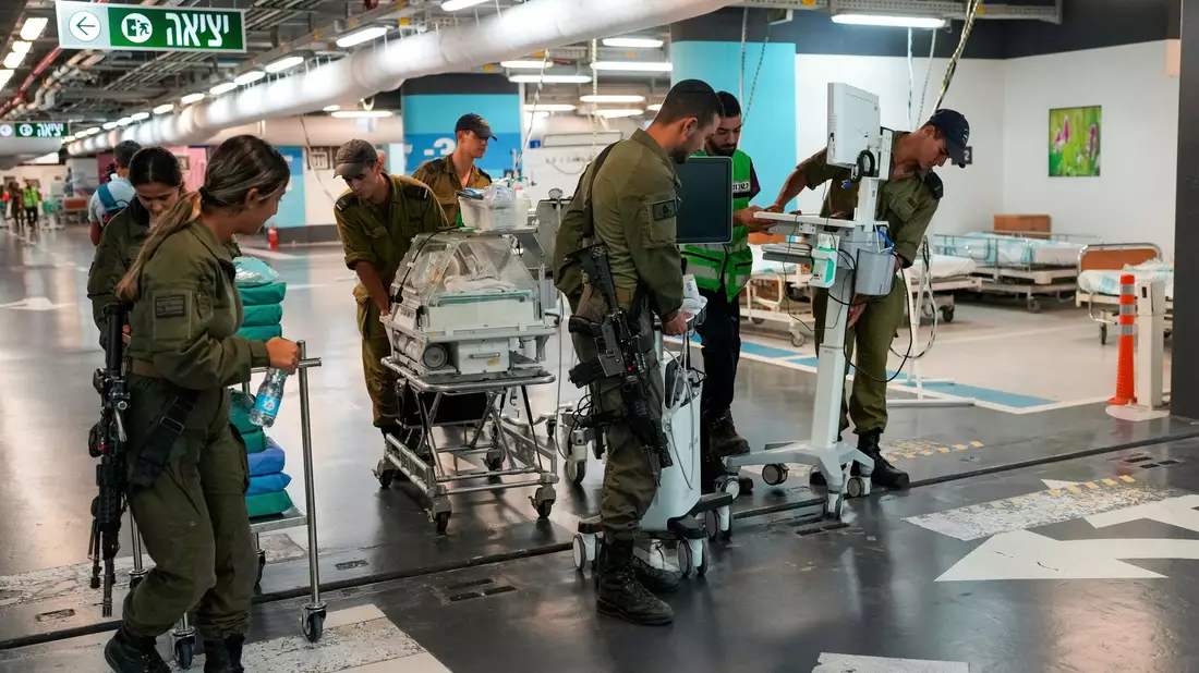 Krankenhauspersonal und Soldaten bringen Patienten und Ausrüstung in die unterirdische Station der Rambam-Klinik. - Bild: Ohad Zwigenberg/AP/dpa