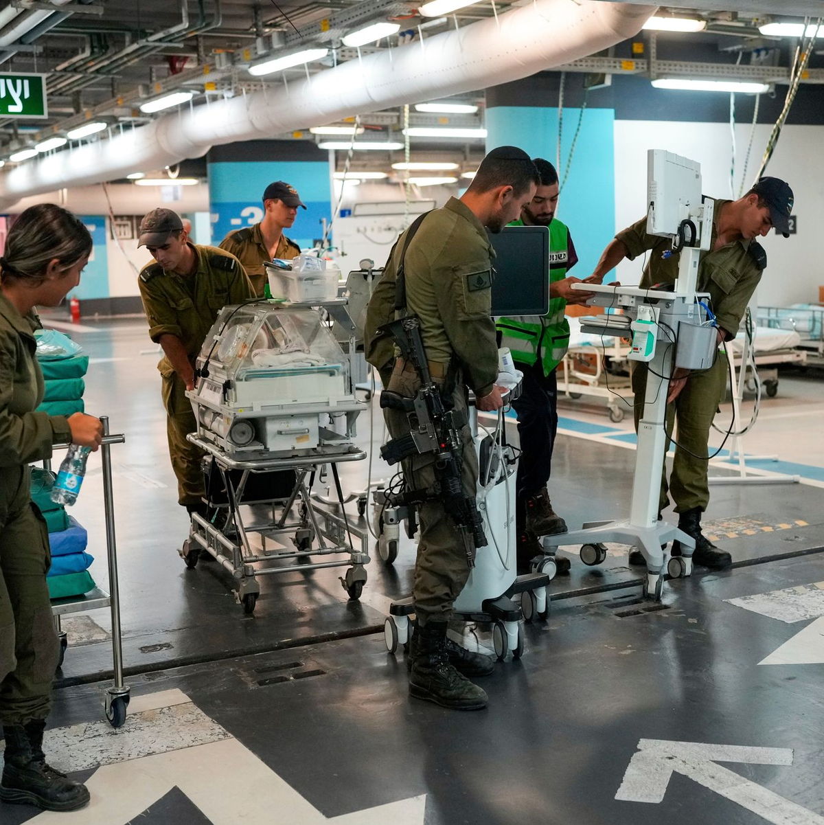Krankenhauspersonal und Soldaten bringen Patienten und Ausrüstung in die unterirdische Station der Rambam-Klinik. - Foto: Ohad Zwigenberg/AP/dpa