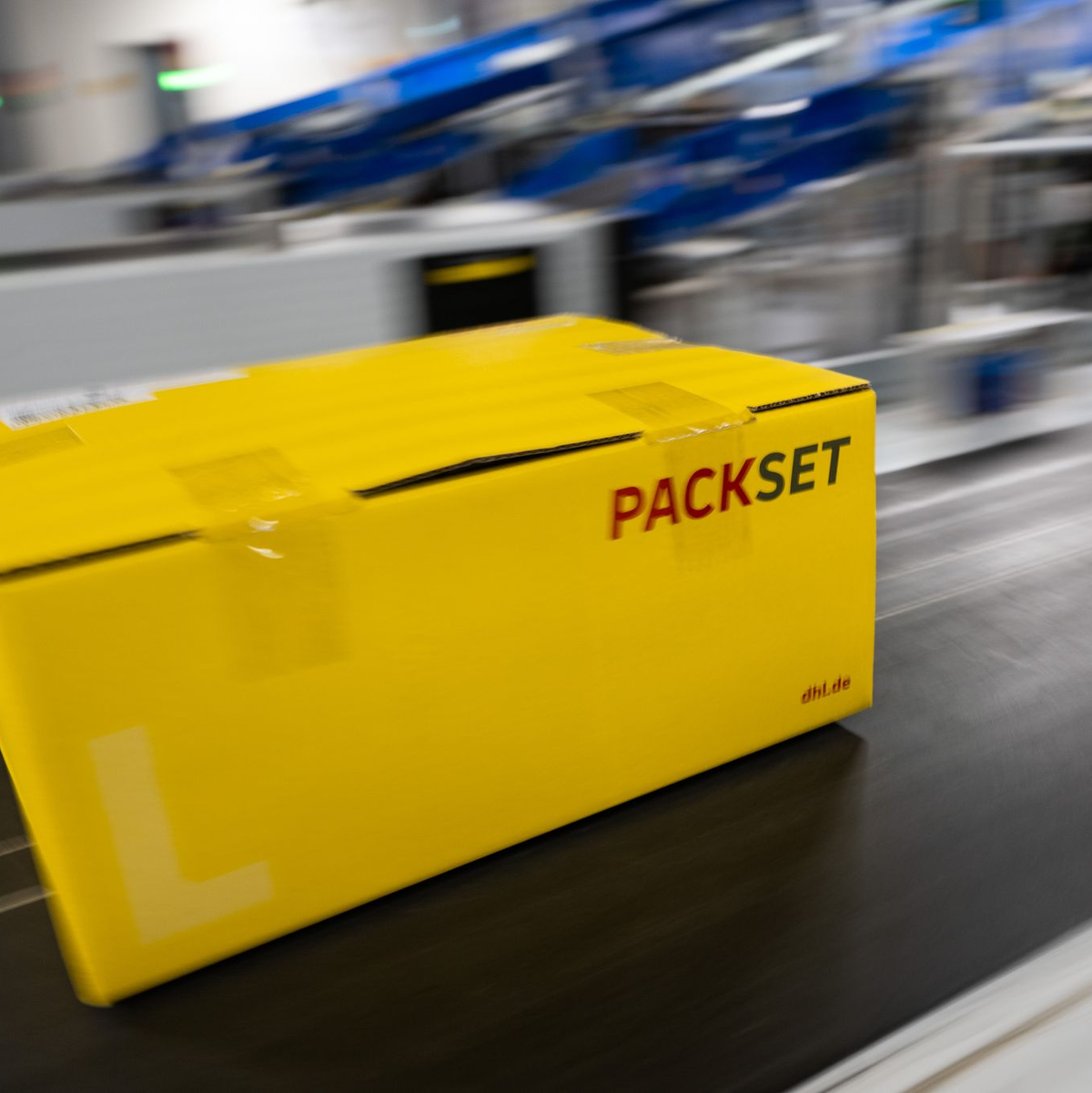 Ein Paket rollt über das Laufband eines DHL-Paketzentrums. - Foto: Christophe Gateau/dpa