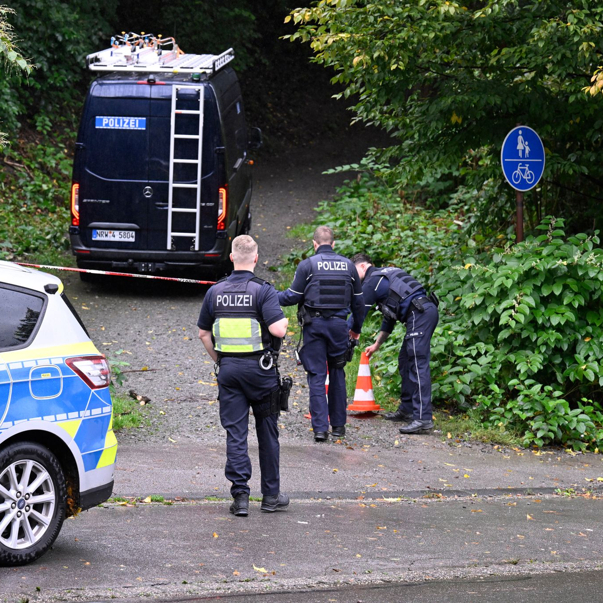 Polizisten sind in der Nähe eines mutmaßlichen Tatorts im Einsatz. Das Gebiet wird gerodet, um nach einem Handy zu suchen. - Foto: Roberto Pfeil/dpa