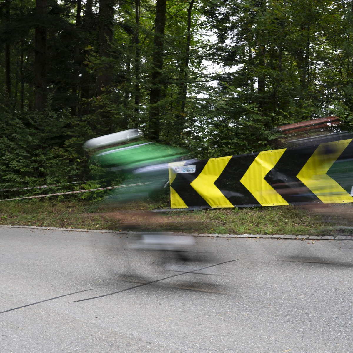Am vermutlichen Unfallort weist ein großes Banner auf eine Kurve hin. - Foto: Til Buergy/KEYSTONE/dpa