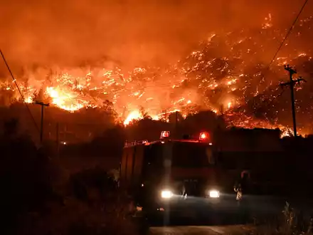 Flammen färben den Himmel glutrot. - Foto: Uncredited/AP