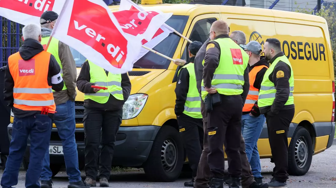 Teilnehmer eines Streiks stehen vor einer Niederlassung von Prosegur in Hamburg. - Bild: Bodo Marks/dpa