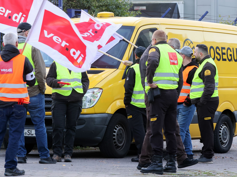 Teilnehmer eines Streiks stehen vor einer Niederlassung von Prosegur in Hamburg. - Foto: Bodo Marks/dpa