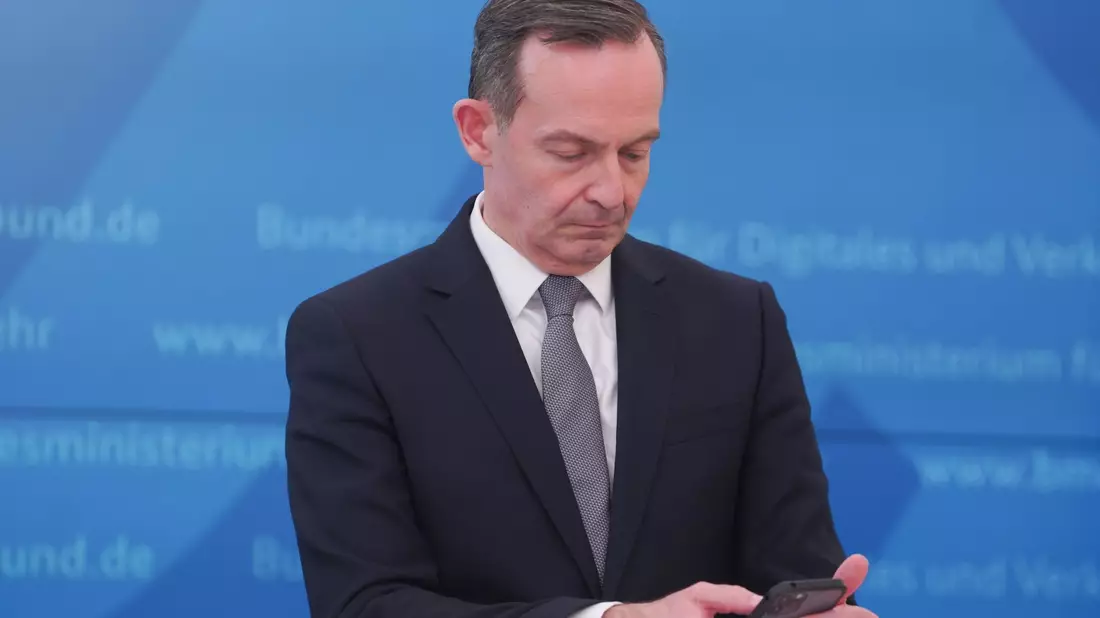 Bundesverkehrsminister Volker Wissing (FDP) blickt bei einer Pressekonferenz im März 2022 auf sein Smartphone. - Bild: Joerg Carstensen/dpa