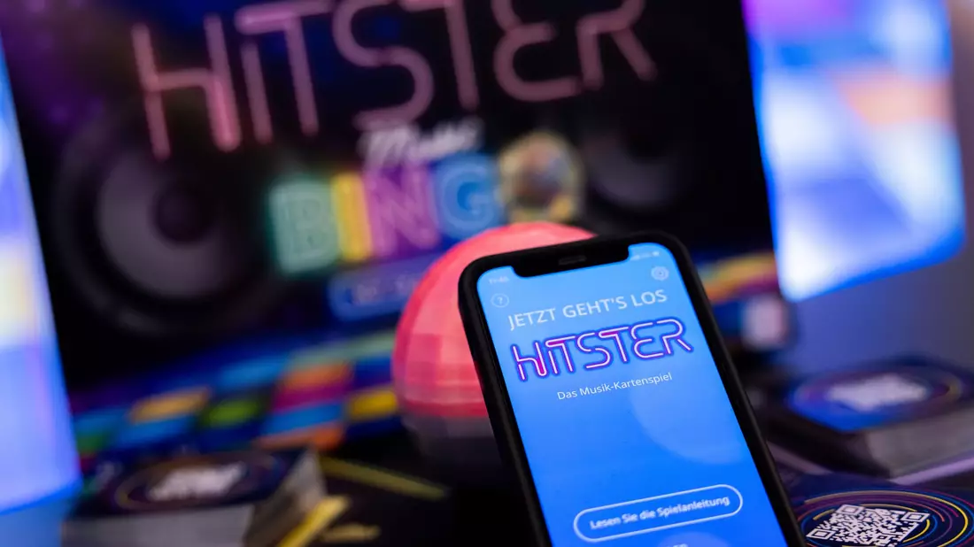 Die App spiel die Musik ein, die Spieler müssen danach die Karten sortieren: Hitster gilt als erfolgreiches Hybrid-Spiel. - Bild: Rolf Vennenbernd/dpa
