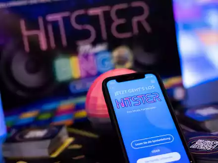 Die App spiel die Musik ein, die Spieler müssen danach die Karten sortieren: Hitster gilt als erfolgreiches Hybrid-Spiel. - Foto: Rolf Vennenbernd/dpa