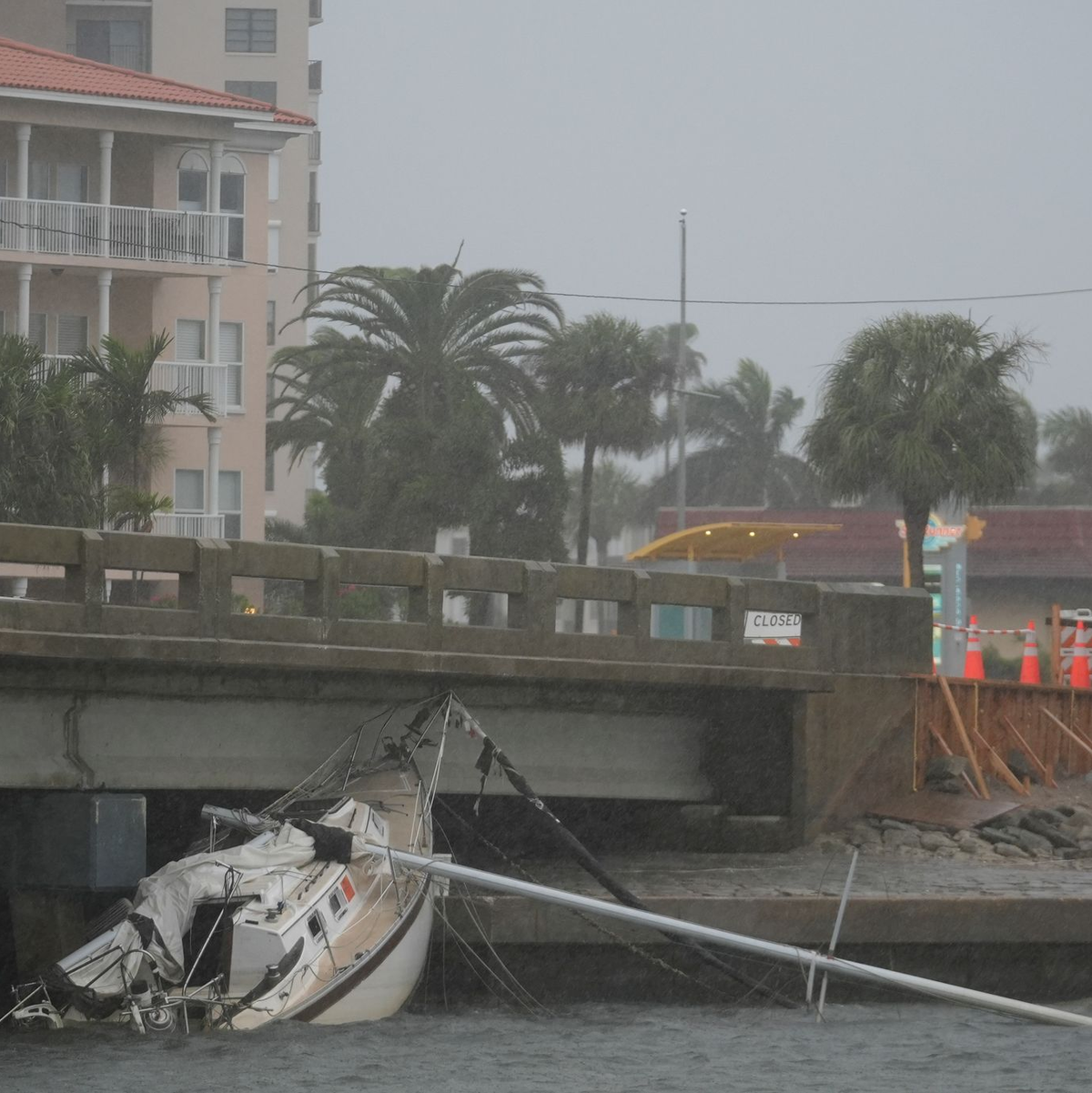Ein von Hurrikan «Helene» beschädigtes Boot liegt unter einer Brücke, während sich «Milton» nähert. - Foto: Rebecca Blackwell/AP