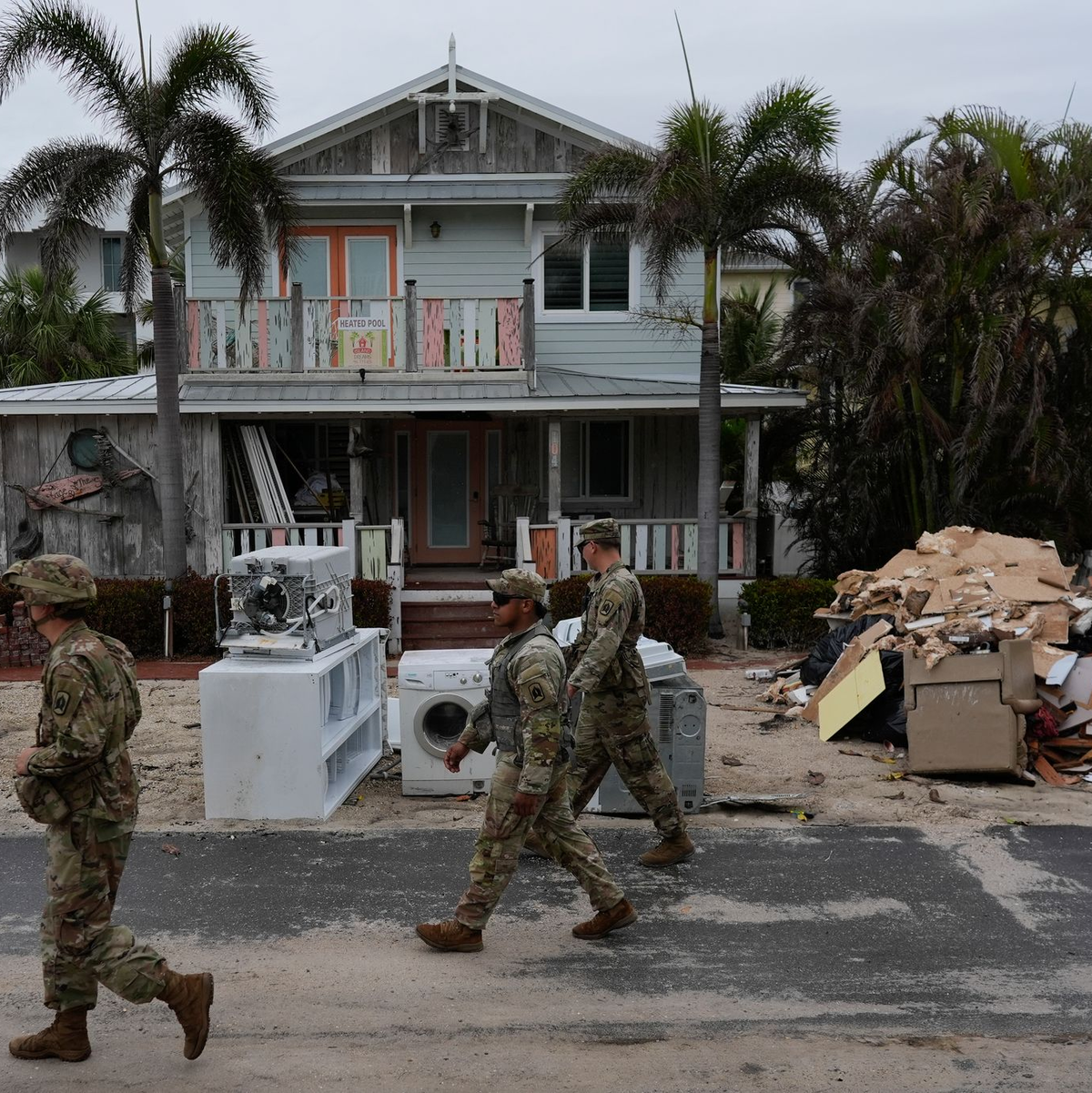 Nationalgardisten suchen nach verbliebenen Bewohnern im fast menschenleeren Bradenton Beach. Den Anwohnern blieb nach Hurrikan «Helene» keine Zeit, die Schuttberge zu beseitigen.  - Foto: Rebecca Blackwell/AP/dpa