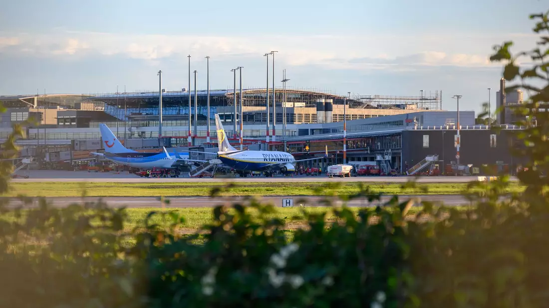 Zwei Flugzeuge stehen vor einem Terminal des Hamburger Flughafens. - Bild: Jonas Walzberg/dpa