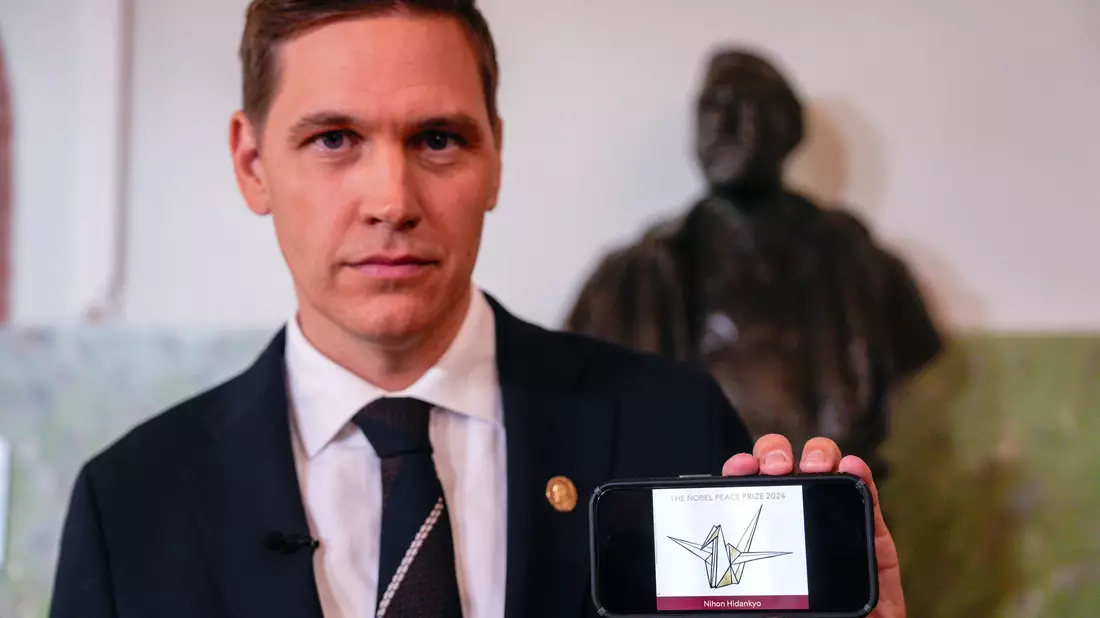 Der Vorsitzende des Nobelkomitees, Jørgen Watne Frydnes, zeigt das Logo der Gewinner-Organisation: eine stilisierte Friedenstaube.  - Bild: Javad Parsa/NTB/dpa