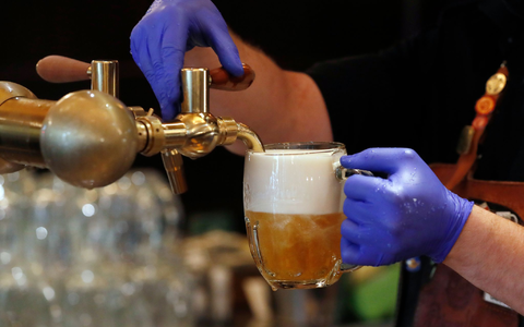Ein Barkeeper zapft ein Bier auf einer Restaurant-Terrasse. (Symbolbild) - Foto: Petr David Josek/AP/dpa