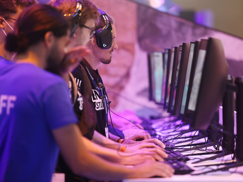 Messebesucher testen ein Computerspiel bei der Gamescom 2022.  - Foto: Oliver Berg/dpa