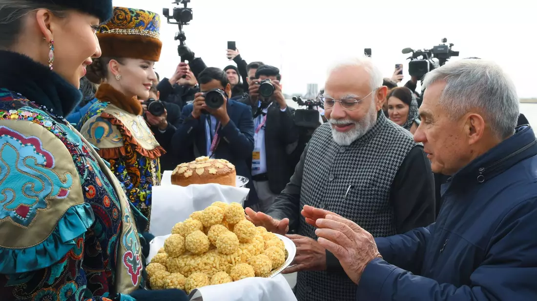 Der indische Premierminister Narendra Modi (2. v. r.) probiert bei seiner Ankunft am Flughafen von Kasan eine traditionelle tatarische Süßigkeit.  - Bild: Ilya Pitalev/brics-russia2024.ru via AP/dpa
