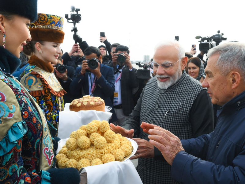 Der indische Premierminister Narendra Modi (2. v. r.) probiert bei seiner Ankunft am Flughafen von Kasan eine traditionelle tatarische Süßigkeit.  - Foto: Ilya Pitalev/brics-russia2024.ru via AP/dpa