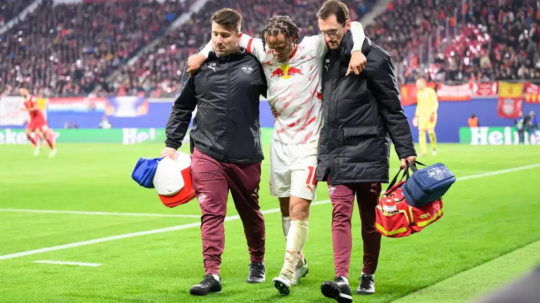 Mit Hilfe von zwei Betreuern verließ Xavi Simons den Platz. - Bild: Robert Michael/dpa