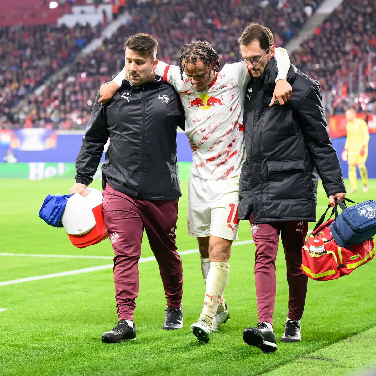 Mit Hilfe von zwei Betreuern verließ Xavi Simons den Platz. - Foto: Robert Michael/dpa