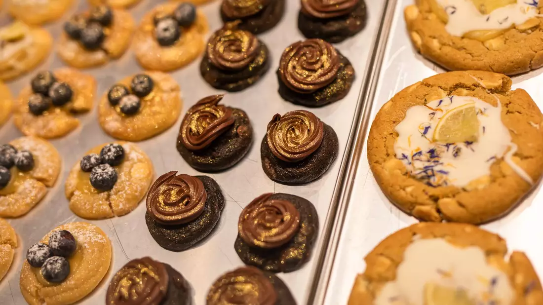 Eine Box mit frisch gebackenen und belegten Cookies präsentiert Mitgründerin Julia Boes. - Bild: Christoph Schmidt/dpa