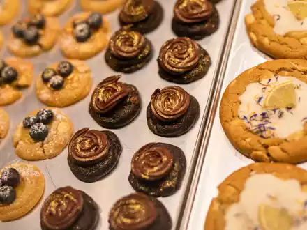 Eine Box mit frisch gebackenen und belegten Cookies präsentiert Mitgründerin Julia Boes. - Foto: Christoph Schmidt/dpa