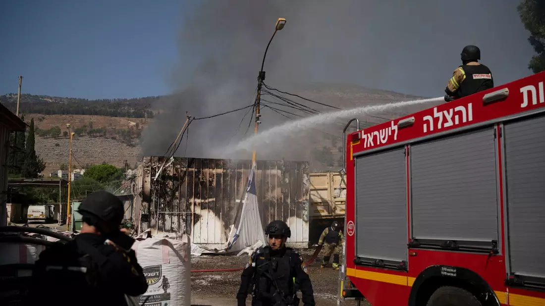 Israelische Feuerwehrleute löschen einen Brand, nachdem eine aus dem Libanon abgefeuerte Rakete im September in den Ort Kiryat Shmona eingeschlagen ist. - Bild: Leo Correa/AP/dpa