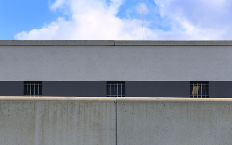 Vergitterte Fenster der Justizvollzugsanstalt Augsburg-Gablingen. Es besteht der Verdacht, dass Gefangene hier geschlagen und in sogenannten besonders gesicherten Hafträumen teils nackt, ohne Decke und ohne Matratze eingesperrt wurden. (Archivbild) - Foto: Karl-Josef Hildenbrand/dpa