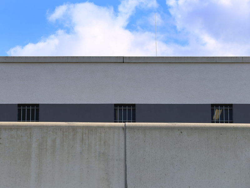 Vergitterte Fenster der Justizvollzugsanstalt Augsburg-Gablingen. Es besteht der Verdacht, dass Gefangene hier geschlagen und in sogenannten besonders gesicherten Hafträumen teils nackt, ohne Decke und ohne Matratze eingesperrt wurden. (Archivbild) - Foto: Karl-Josef Hildenbrand/dpa