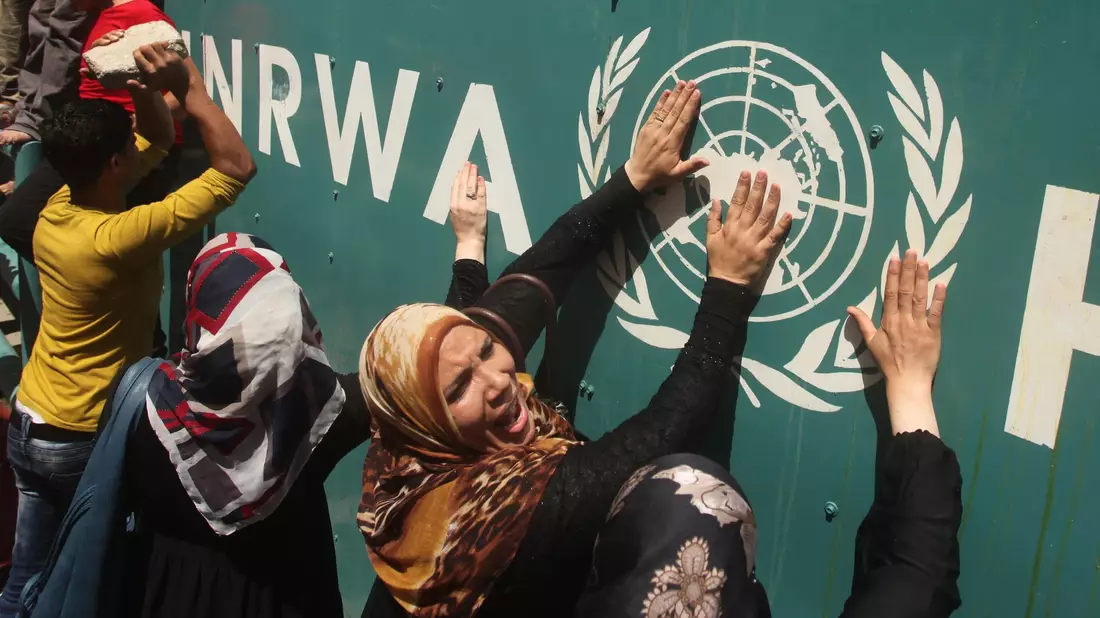 Palästinenserinnen vor UNRWA-Schild (Archivbild) - Bild: Ashraf Amra/APA Images via ZUMA Wire/dpa