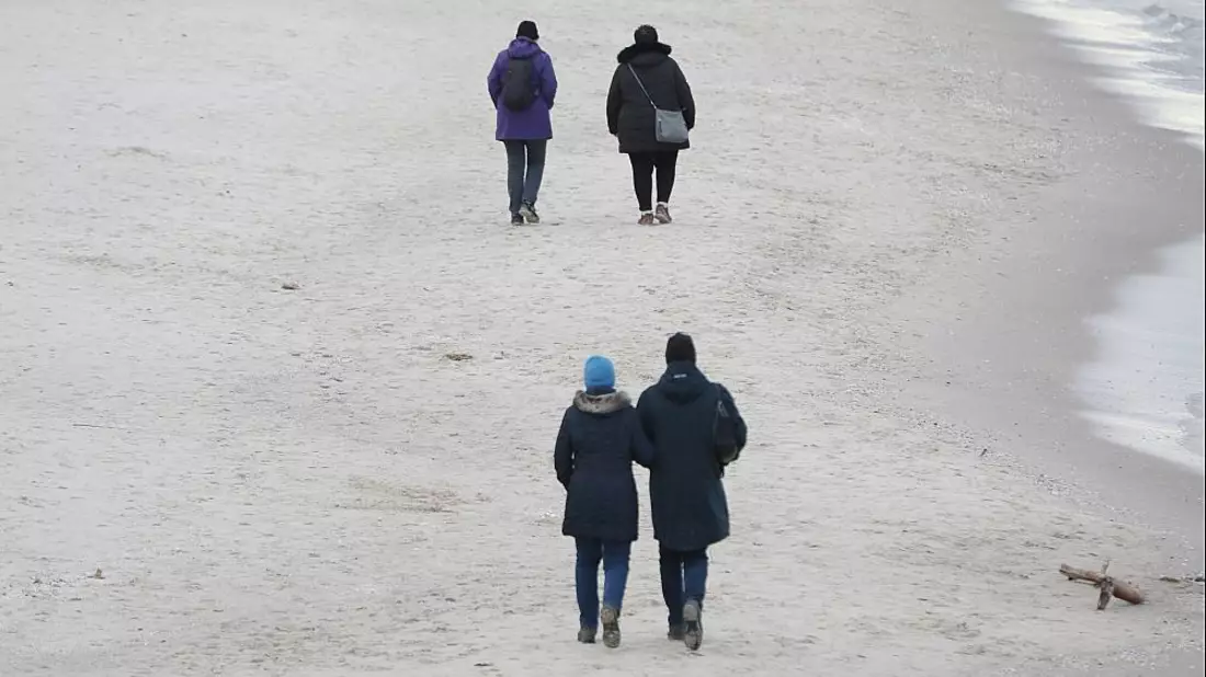 Paare gehen am Strand spazieren - Bild: über dts Nachrichtenagentur