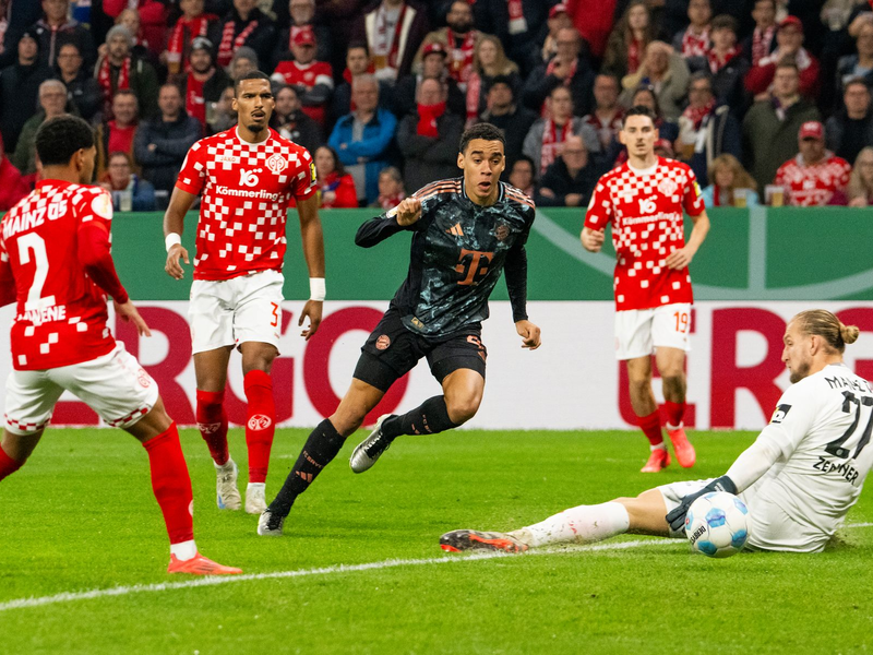 Jamal Musiala, hier beim Pokalspiel in Mainz, ist von den Gegenspielern kaum mit fairen Mitteln vom Ball zu trennen. - Foto: Torsten Silz/dpa