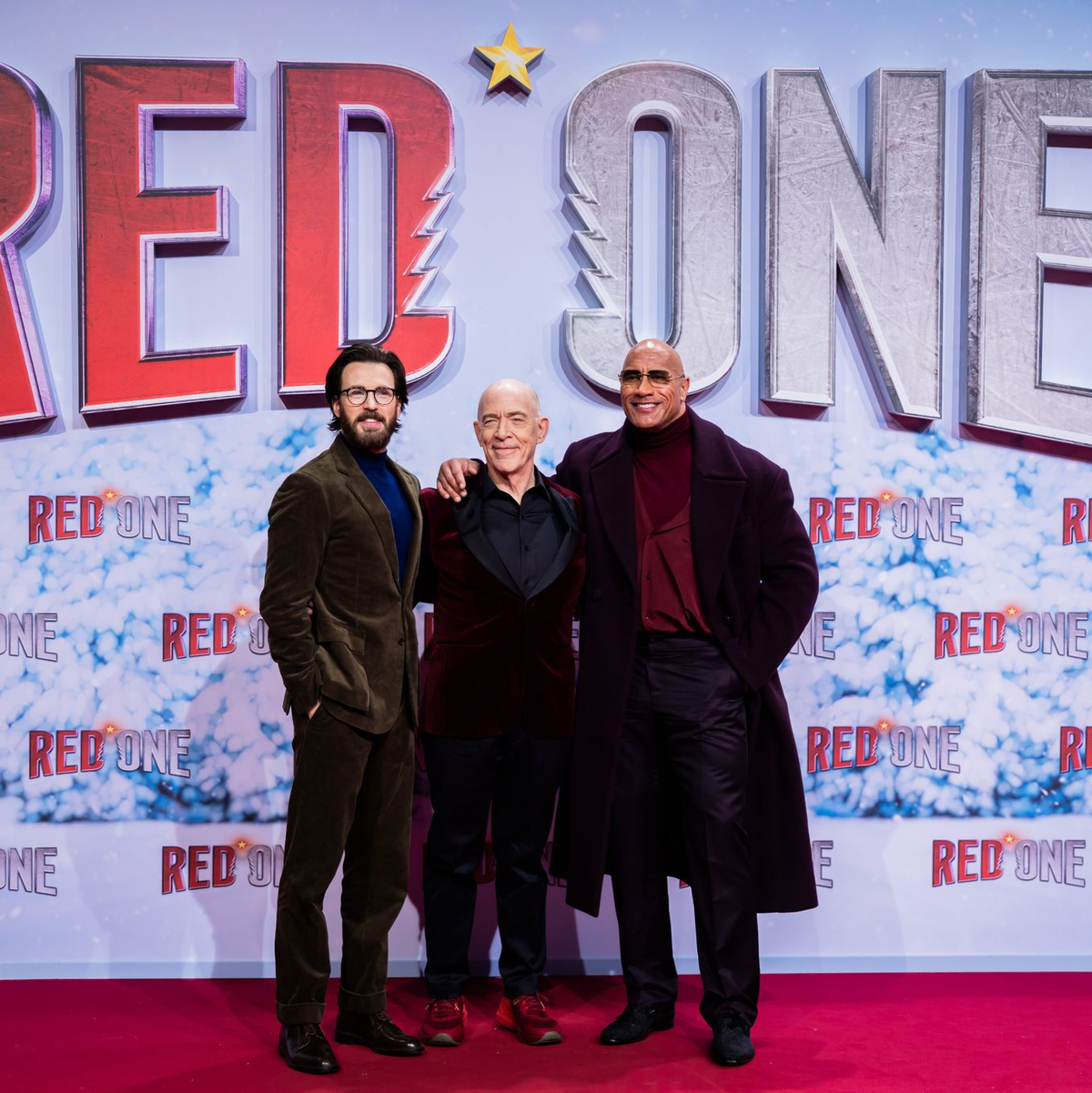 Chris Evans (l-r), J.K. Simmons und Dwayne Johnson auf dem Roten Teppich zur Weltpremiere des Films «Red One – Alarmstufe Weihnachten».  - Foto: Christoph Soeder/dpa