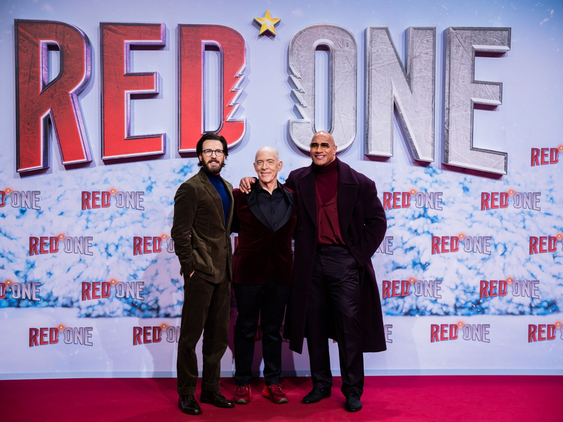 Chris Evans (l-r), J.K. Simmons und Dwayne Johnson auf dem Roten Teppich zur Weltpremiere des Films «Red One – Alarmstufe Weihnachten».  - Foto: Christoph Soeder/dpa