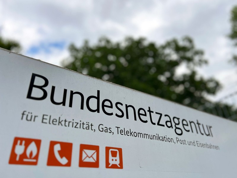 Ein Schild mit der Aufschrift «Bundesnetzagentur» steht vor dem Eingang des Dienstsitzes der Regulierungsbehörde. - Foto: Wolf von Dewitz/dpa