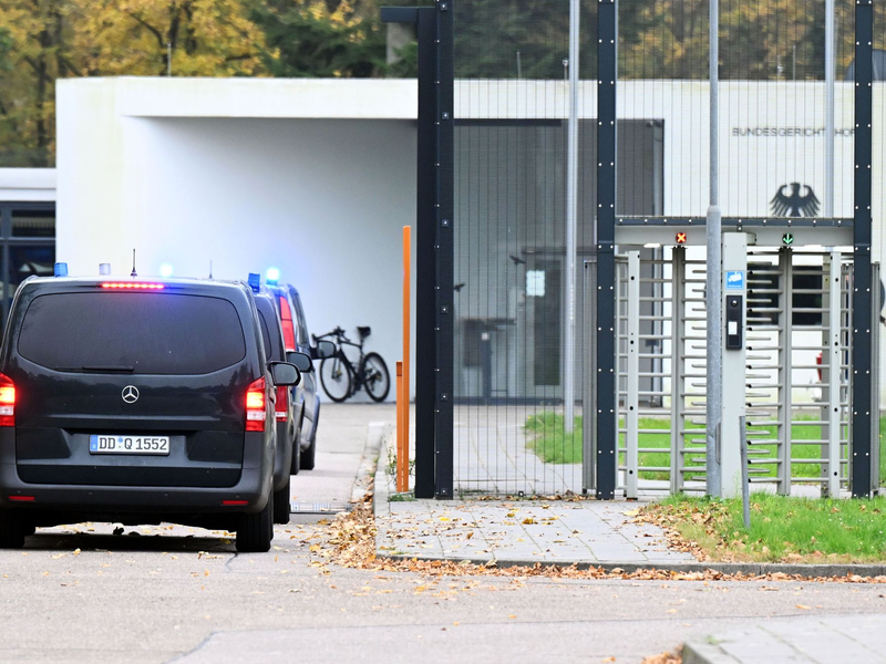 Mit eingeschaltetem Blaulicht fahren mehrere Wagen auf den Hof an der Außenstelle des Bundesgerichtshofs. (Archivbild) - Foto: Uli Deck/dpa