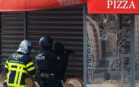 Polizisten stehen vor dem Restaurant in Issy-les-Moulineaux. - Foto: Ian Langsdon/AFP/dpa