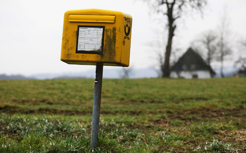 Ein Briefkasten der Deutschen Post steht auf einer Wiese am Rand einer Siedlung im Bergischen Land (NRW).  - Foto: Oliver Berg/dpa