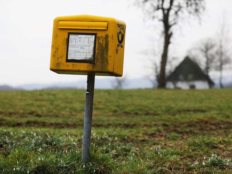 Ein Briefkasten der Deutschen Post steht auf einer Wiese am Rand einer Siedlung im Bergischen Land (NRW).  - Foto: Oliver Berg/dpa