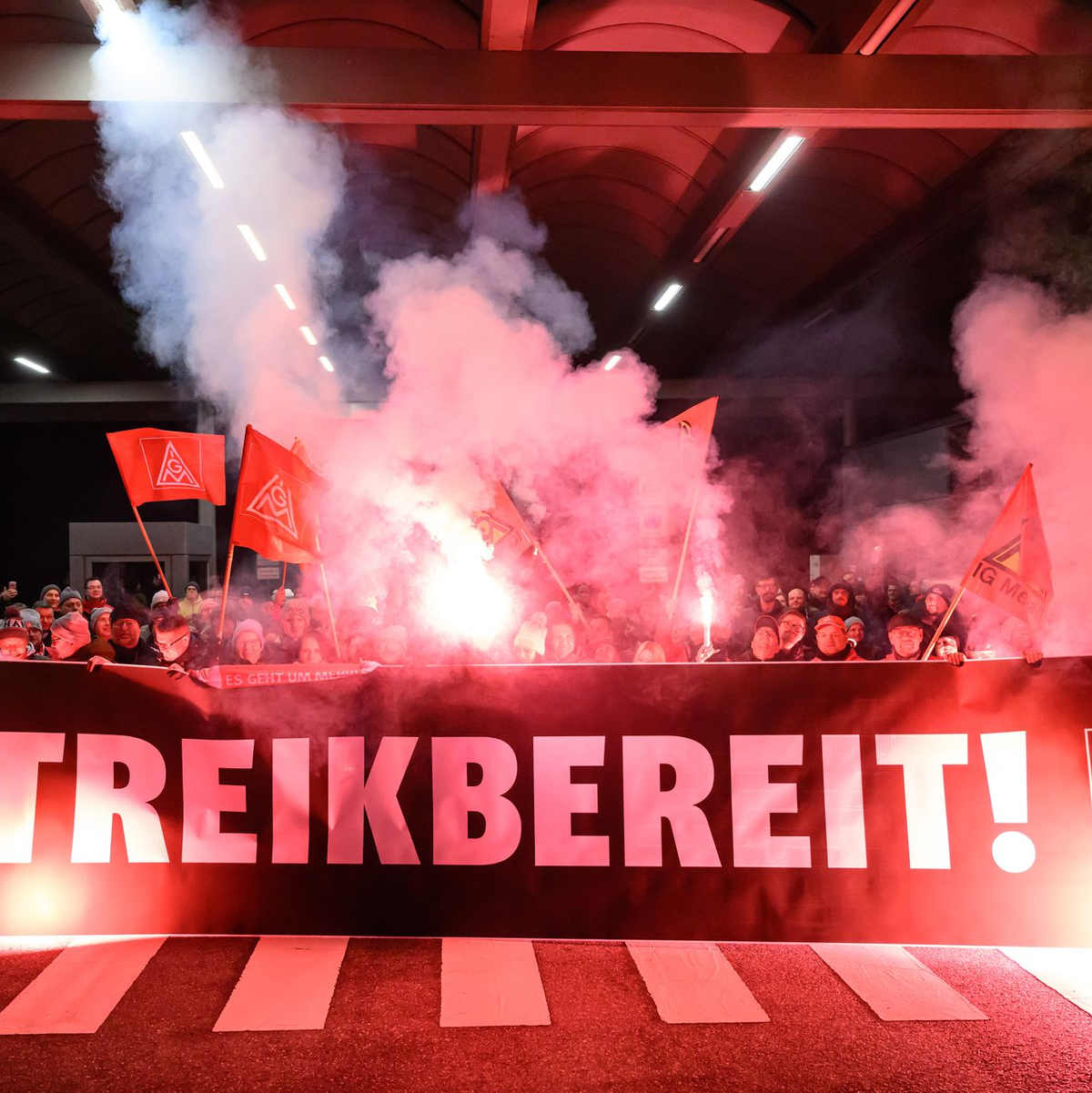 Mit rotem Bengalfeuer zeigten die Mitarbeiter in Zwickau ihren Unmut. - Foto: Hendrik Schmidt/dpa