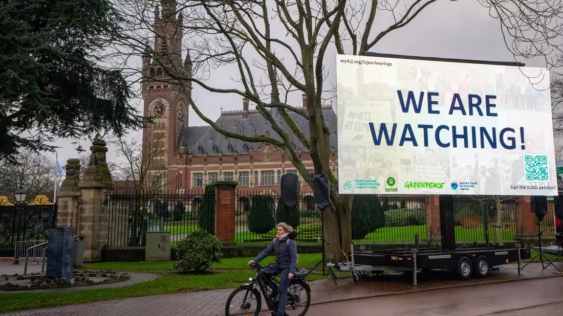 «We are Watching!» ist auf einem Plakat vor dem Internationalen Gerichtshof zu lesen: Das höchste UN-Gericht befasst sich mit Klimaschutz. - Bild: Peter Dejong/AP/dpa