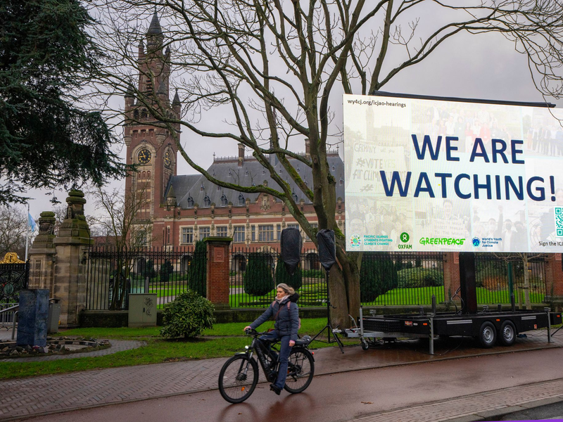 «We are Watching!» ist auf einem Plakat vor dem Internationalen Gerichtshof zu lesen: Das höchste UN-Gericht hat sich mit Klimaschutz befasst. (Archivbild) - Foto: Peter Dejong/AP/dpa