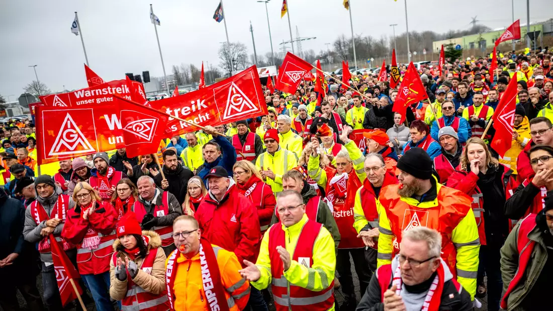 Streikende stehen vor dem Volkswagen-Werk Emden. - Bild: Sina Schuldt/dpa