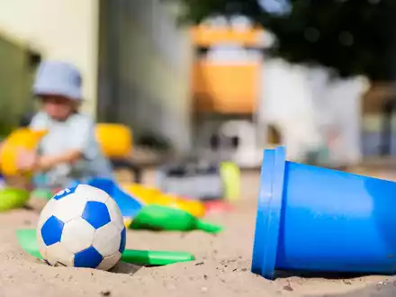 Ein Kind spielt in einem Sandkasten - wo haben dessen Eltern wohl Eimerchen, Schaufeln und den kleinen Ball gekauft, im Internet oder im Geschäft? - Foto: Christoph Soeder/dpa