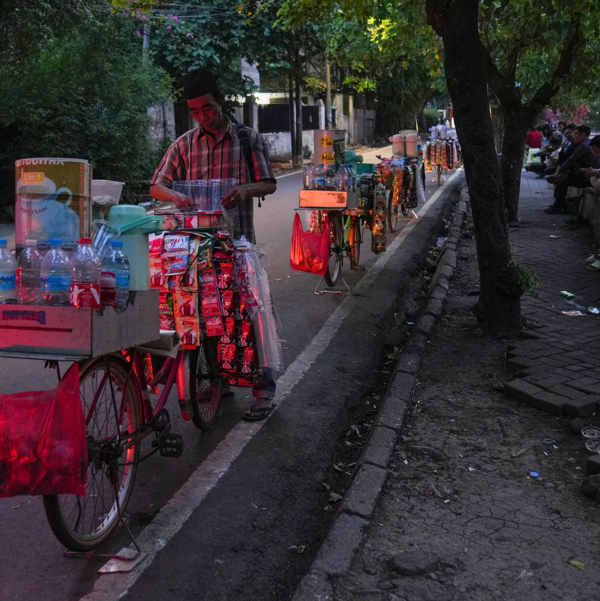 Mit Thermoskannen und Eisboxen sind die Fahrer unterwegs. - Foto: Tatan Syuflana/AP