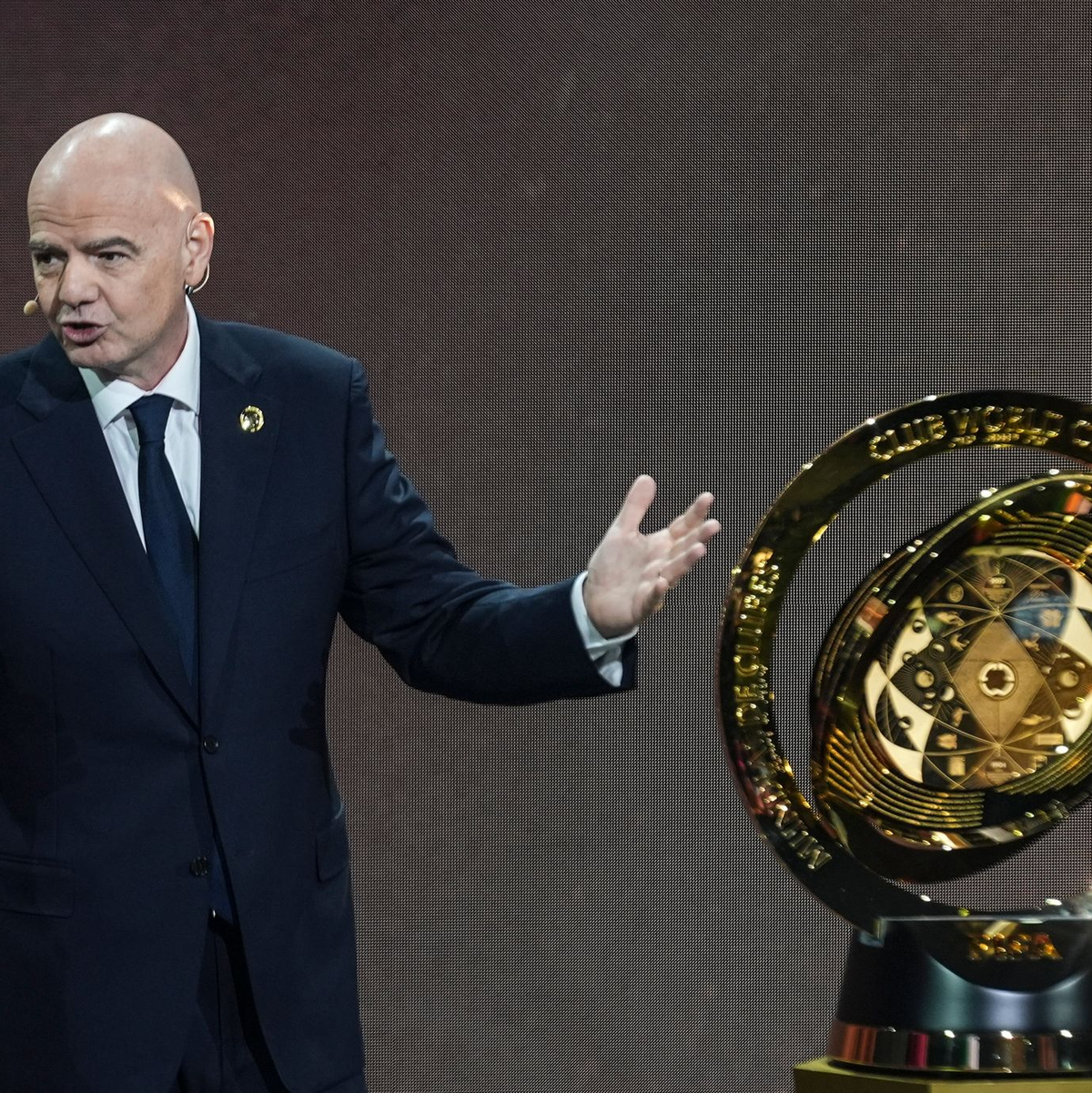FIFA-Präsident Gianni Infantino und der frühere brasilianische Fußballstar Ronaldo präsentieren bei der Auslosung der Club-WM die Siegertrophäe. - Foto: Rebecca Blackwell/AP/dpa