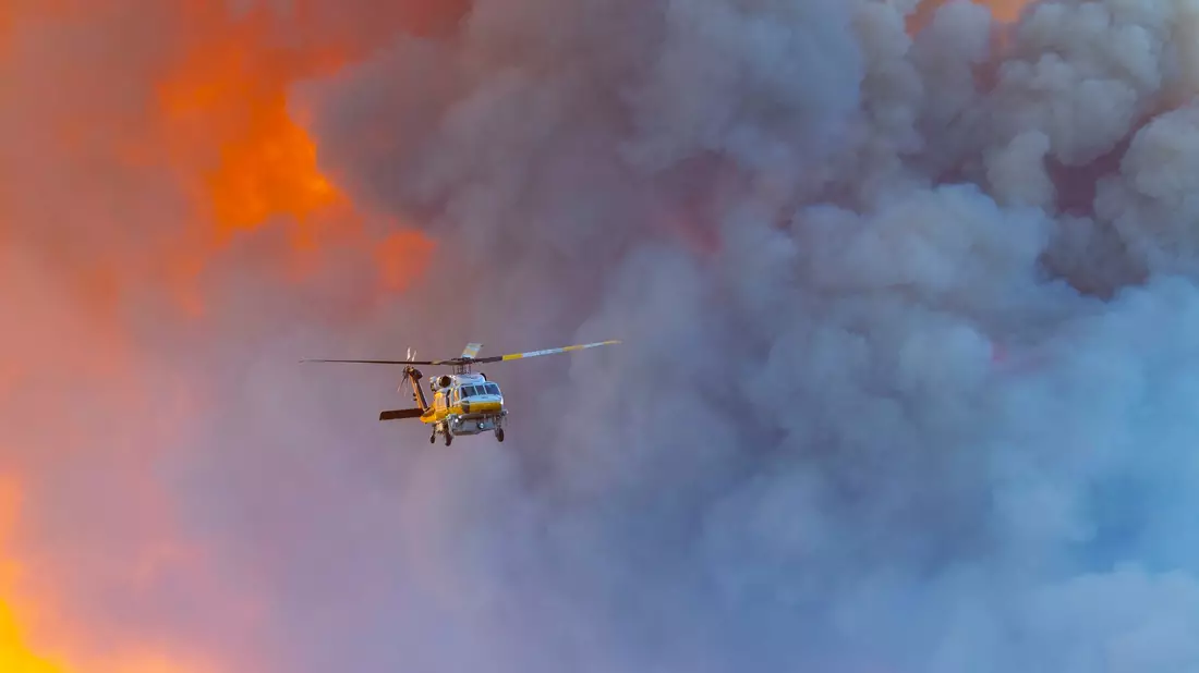 Löschhubschrauber versuchen, Häuser zu schützen. - Bild: Jill Connelly/ZUMA Press Wire/dpa
