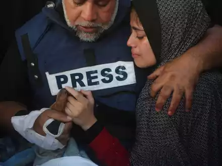 Der Al-Dschasira-Journalist Wael al-Dahdu hält die Hand seines Sohns Hamza, der ebenfalls für Al-Dschasira arbeitete und bei einem israelischen Luftangriff im Gazastreifen getötet wurde. - Foto: Hatem Ali/AP/dpa