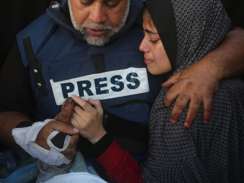Der Al-Dschasira-Journalist Wael al-Dahdu hält die Hand seines Sohns Hamza, der ebenfalls für Al-Dschasira arbeitete und bei einem israelischen Luftangriff im Gazastreifen getötet wurde. - Foto: Hatem Ali/AP/dpa