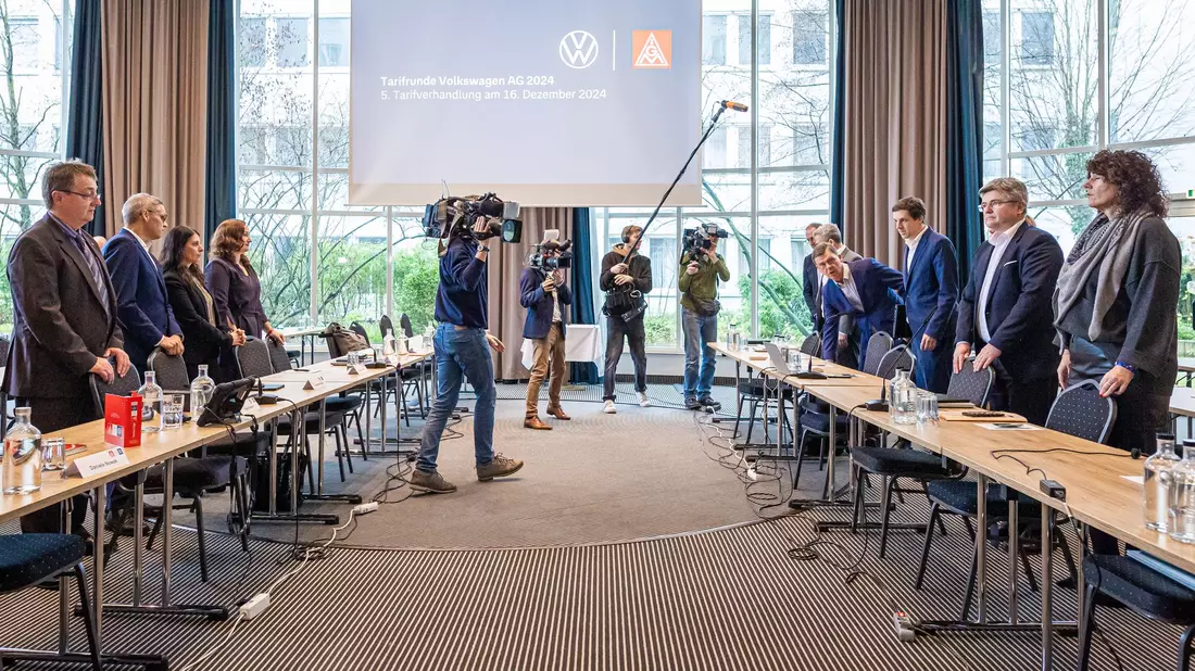 Vertreter von Volkswagen (r) und IG Metall (l) vor Beginn der fünften Tarifverhandlung in Hannover. - Bild: Moritz Frankenberg/dpa
